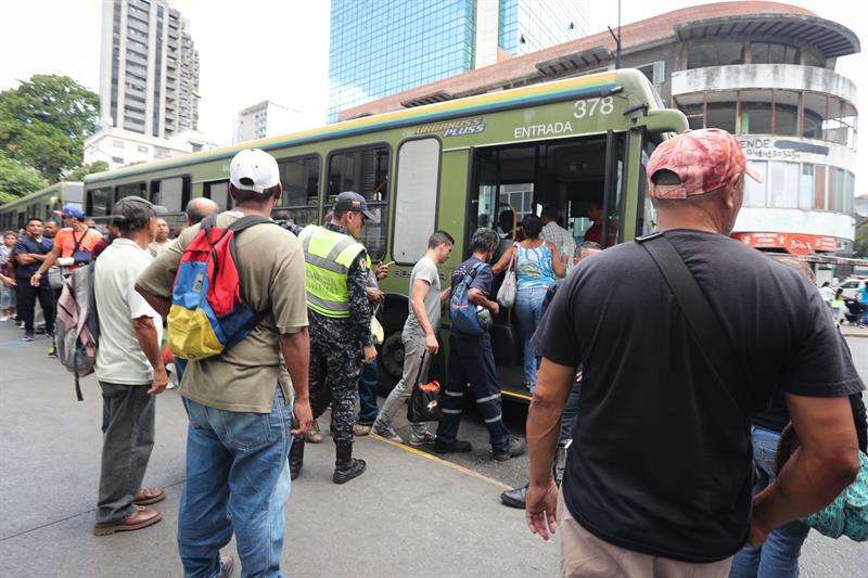 Un grupo de personas toma autobuses de servicio público hoy, jueves en Caracas. Los venezolanos reanudan sus actividades luego del fallo eléctrico que hace una semana afectó casi todo el país y por el que se paralizaron los servicios durante al menos 100 