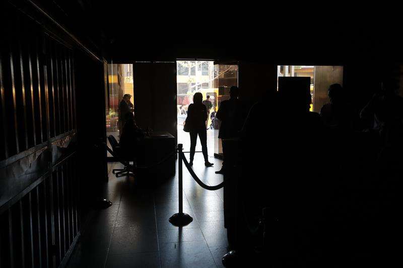 Un grupo de personas permanece en medio de la oscuridad al interior del edificio de la Asamblea Nacional este lunes en Caracas (Venezuela). EFE
