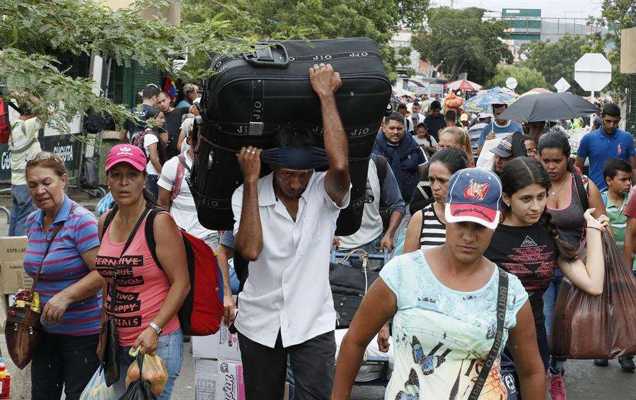 Ciudadanos venezolanos regresan con sus maletas llenas de provisiones por el puente internacional Simón Bolívar este sábado, en Cúcuta (Colombia). EFE