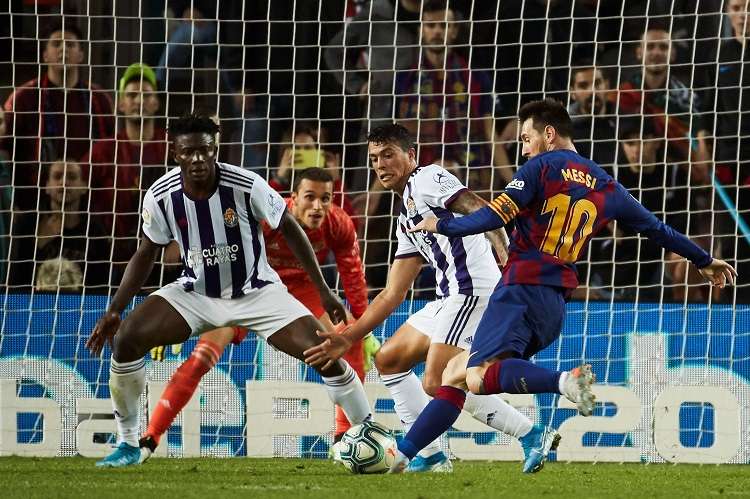 El delantero argentino del FC Barcelona, Leo Messi (d), se dispone a golpear el balón ante los defensores del Valladolid. Foto: AP