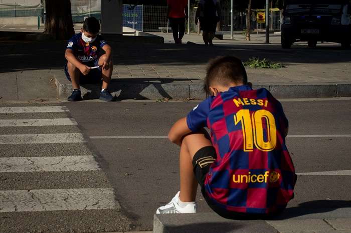 -Dos jóvenes aficionado esperan a la entrada de la ciudad deportiva Joan Gamper en Barcelona las llegada de los jugadores. /EFE