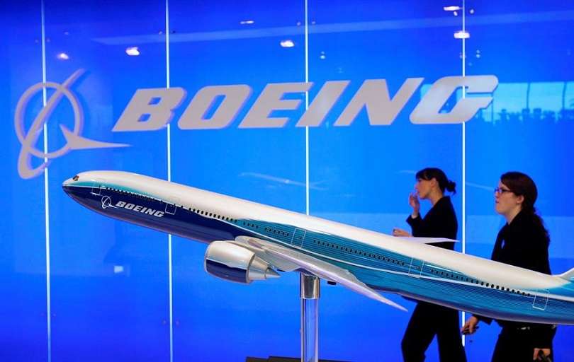 El personal de Boeing pasa junto a un modelo de avión de Boeing en exhibición en el Singapore Airshow en Singapur. EFE