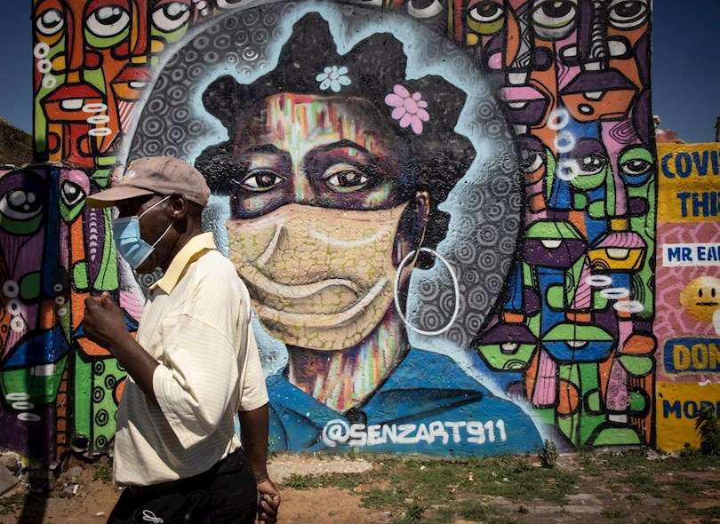 Una persona camina junto a un mural en Soweto, en una imagen de archivo. EFE