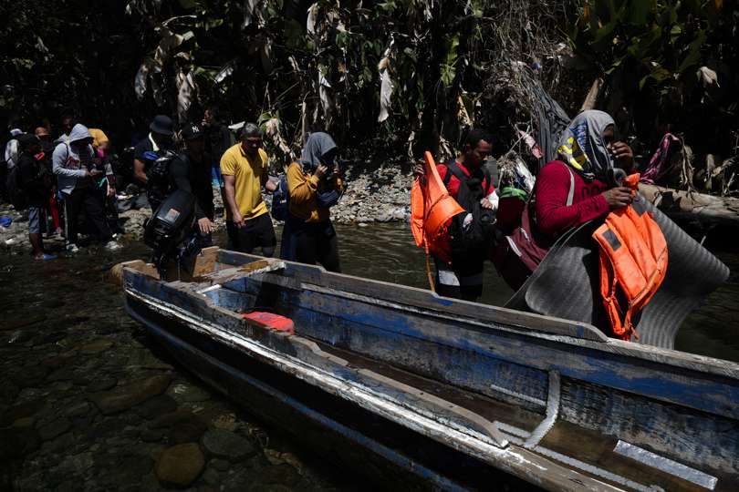 Personas migrantes esperan en la selva para ser trasladados en canoa desde la Quebrada León hasta a la comunidad de Bajo Chiquito. EFE