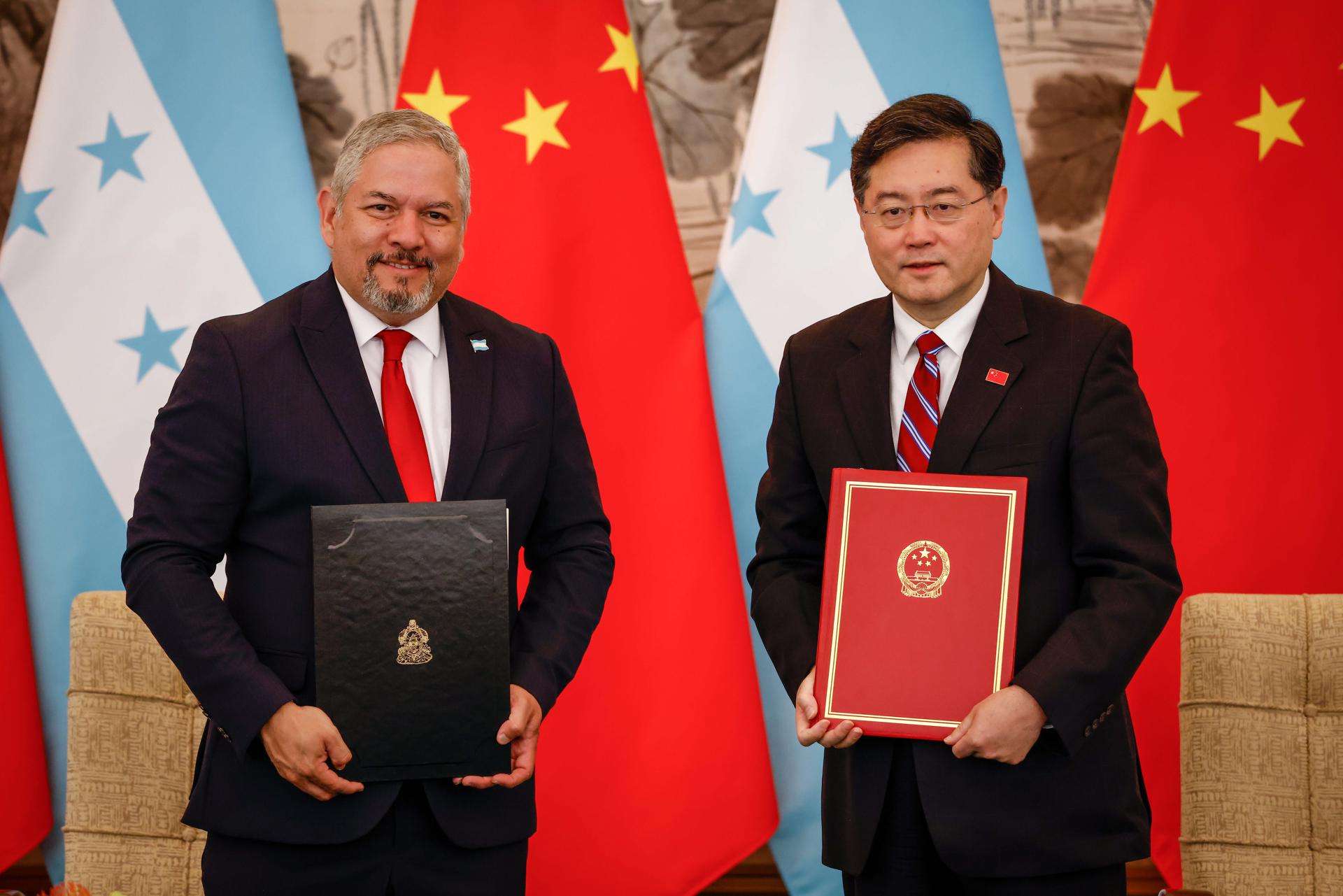El ministro de Exteriores de Honduras, Eduardo Reina (I), y su homólogo de China, Qin Gang (D), tras firmar el restablecimiento de relaciones diplomáticas