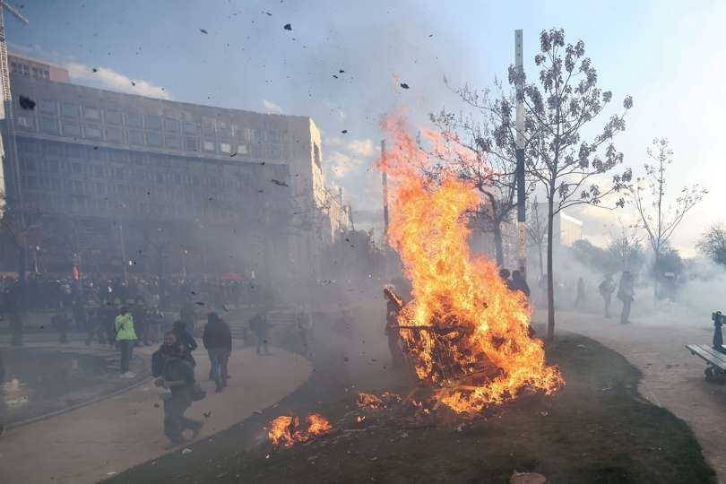 Los manifestantes encienden un fuego durante los enfrentamientos con la policía antidisturbios francesa en una manifestación contra la reforma del gobierno al sistema de pensiones en París, Francia. EFE