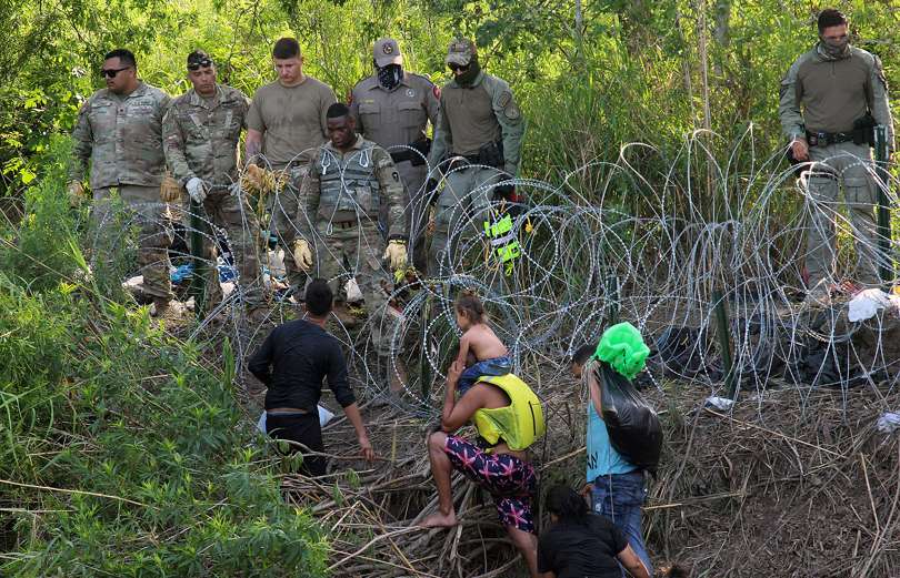 Militares observan a migrantes luego de cruzar el río Bravo para intentar ingresar a Estados Unidos en Matamoros (México). EFE
