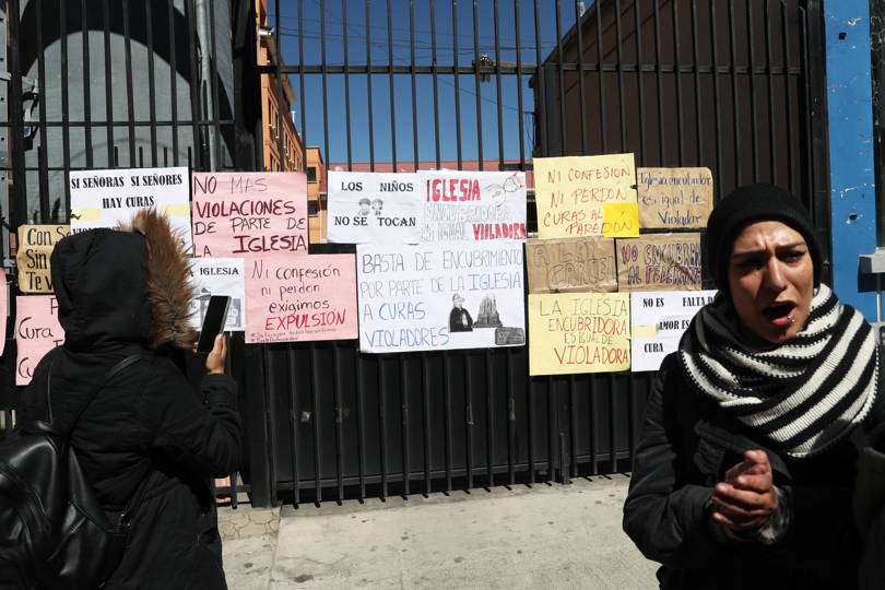 Varias personas protestan en contra de la Iglesia católica pegando carteles en las puertas del seminario San Jerónimo, en La Paz (Bolivia). EFE