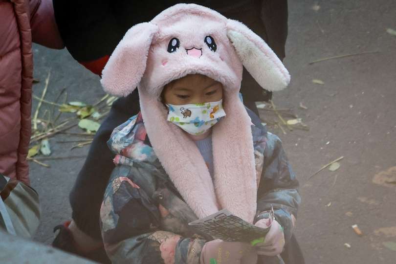 Un niño usa una mascarilla después de ser despedido de una escuela en Beijing, China