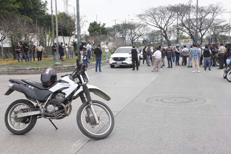 Vistas del momento cuando policías investigaban el vehículo con impactos de bala en el que se encontraba el fiscal César Suárez al ser asesinado. EFE