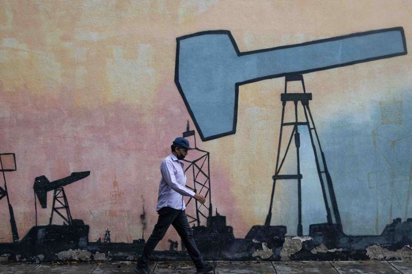 Un hombre pasa frente a un mural que muestra el proceso de extracción de petróleo frente a una sede de la estatal Petróleos de Venezuela S.A (Pdvsa). EFE