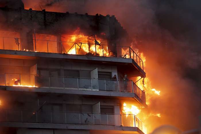 Dos personas aguardan en el balcón a ser rescatadas en el incendio declarado sobre las cinco y media de esta tarde en un quinto piso de un edificio de viviendas de València. EFE