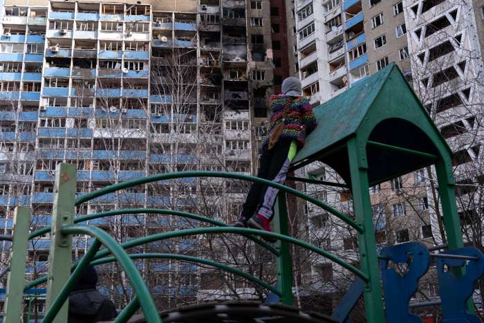 Fotografía tomada en Kiev, Ucrania, desde un parque infantil en la que una niña observa los apartamentos quemados.