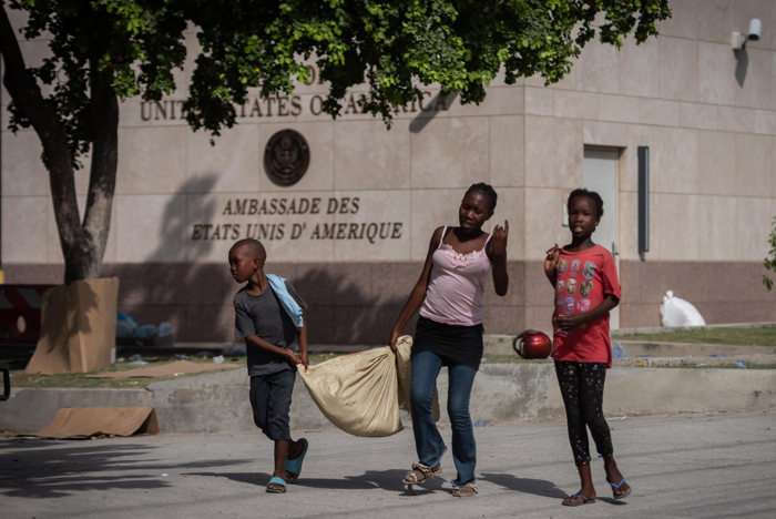 Personas caminan frente a la embajada de Estados Unidos, en Puerto Príncipe (Haití). EFE / Archivo