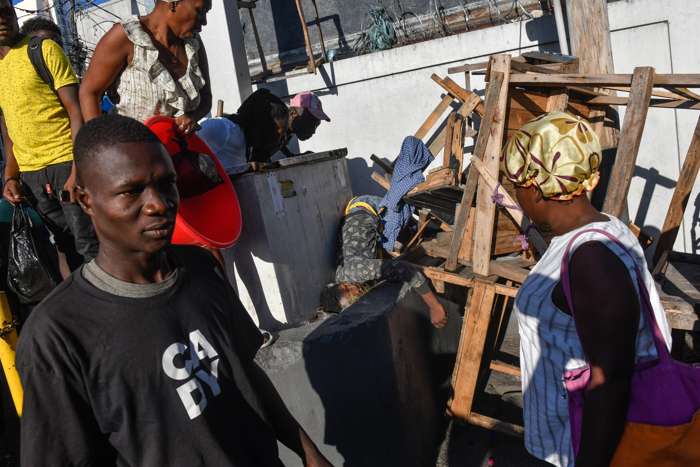 Varias personas observan el cadáver de una persona en el suelo este lunes, en Puerto Príncipe (Haití). EFE