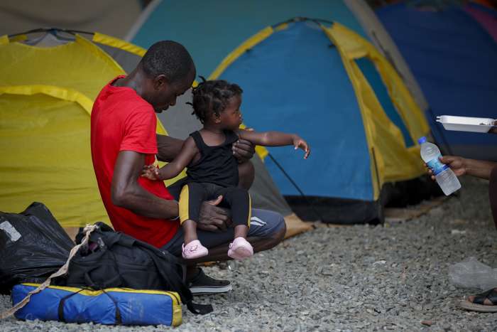 Un migrante descansa con una niña en la estación de recepción migratoria de Lajas Blancas.EFE