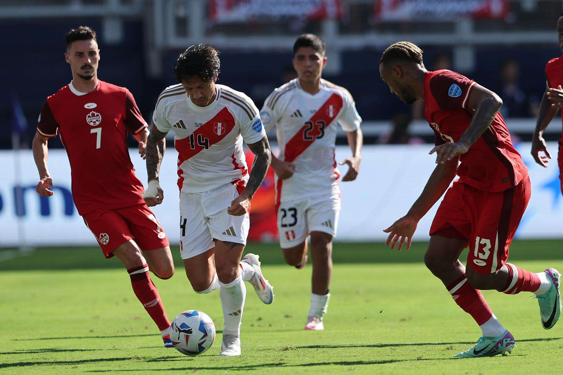 El canadiense Stephen Eustaquio (i) disputa un balón con el peruano Gianluca Lapadula (c). /Foto: EFE