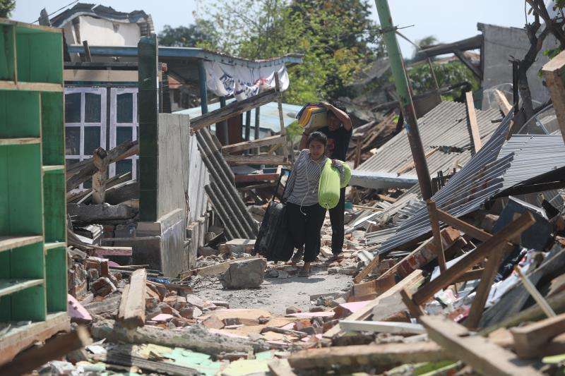 Residentes cargan con sus pertenencias entre los escombros tras los terremotos que desde el pasado domingo azotan el norte de la isla de Lombok (Indonesia). EFE