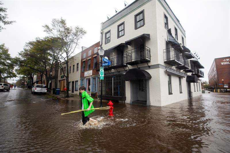 Fotografía tomada el pasado 14 de septiembre en la que se registró a varios afectados, al caminar por una calle inundada en Wilmington (Carolina del Norte, EE.UU.), tras el paso del huracán Florence. EFE/Archivo