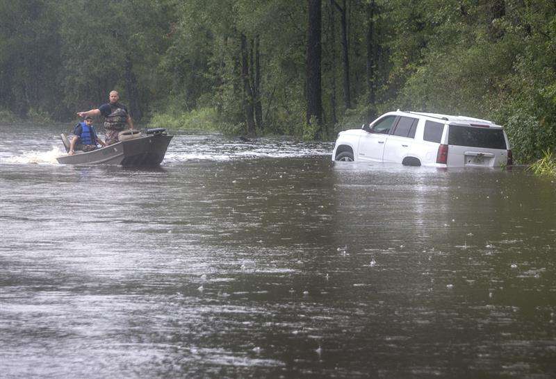 Efectivos de los cuerpos de rescate navegan en una pequeña lancha por una calle inundada de Latta, Carolina del Sur, EE.UU. EFE