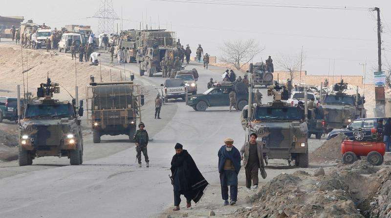 Miembros de las fuerzas de seguridad afganas inspeccionan el lugar tras un atentado suicida perpetrado contra un vehículo de las fuerzas de seguridad en Paghman, a las afueras de Kabul (Afganistán) este 11 de diciembre. EFE