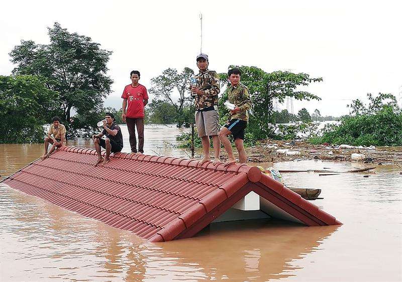 Un grupo de personas aguarda en lo alto de un tejado en una zona inundada tras el derrumbe de una presa hidroeléctrica en un pueblo cercano a la provincia de Attapeu, en Laos, este 24 de julio. EFE
