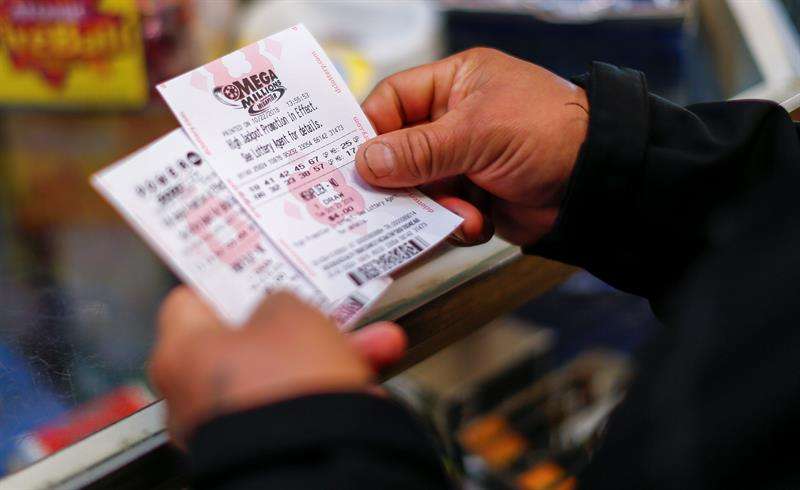 Un cliente compra boletos de lotería Mega Millions en una tienda minorista. EFE