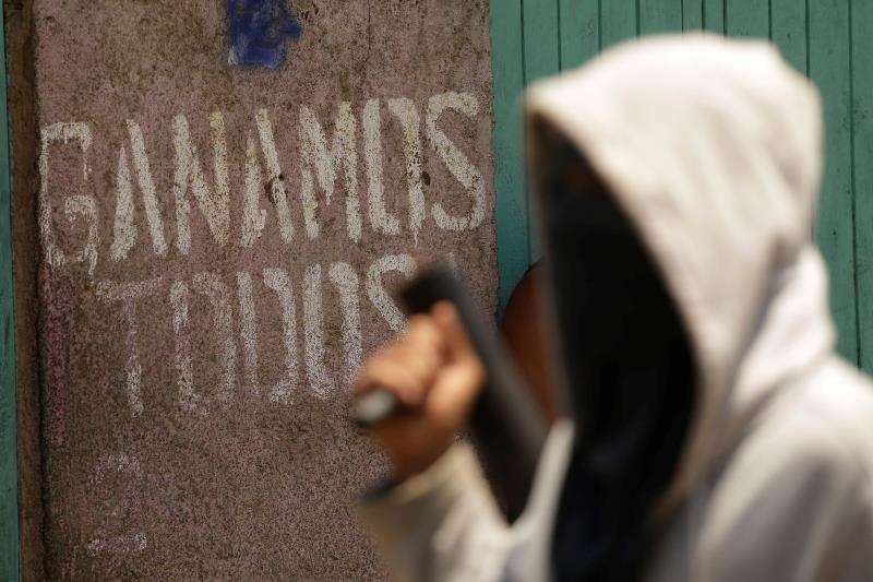 Un manifestante encapuchado camina frente a una pintada en Masaya (Nicaragua). EFEArchivo