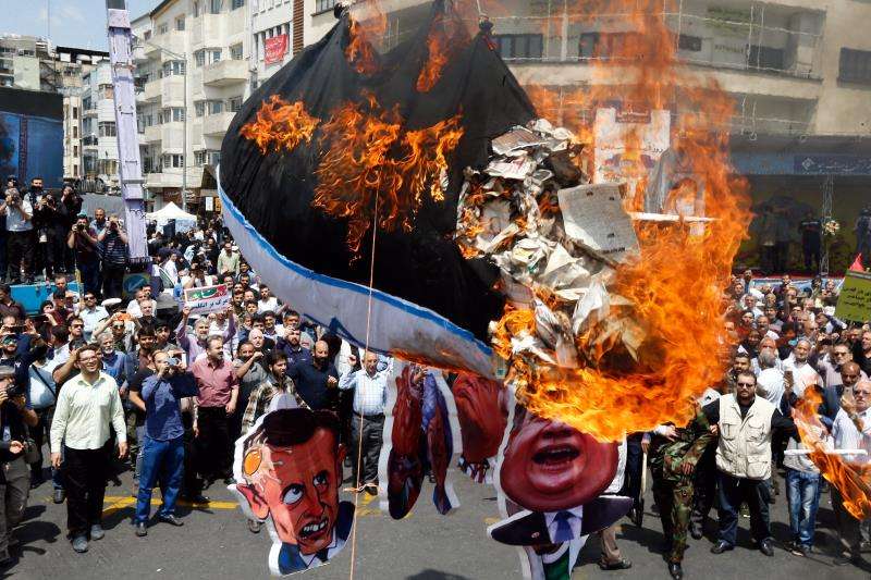 Iraníes queman la bandera israelí durante una protesta en Teherán (Irán), este viernes. EFE