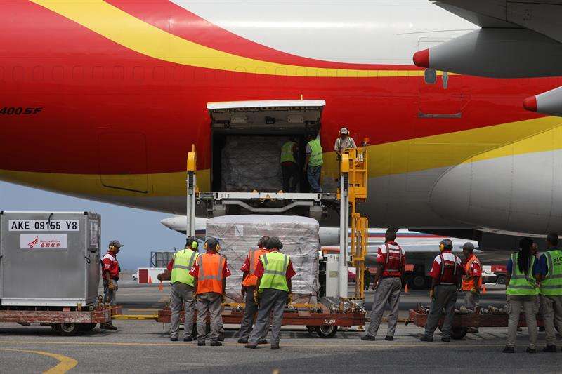 Personal descarga un avión proveniente de China que trae materiales médicos descartables, este viernes en el Aeropuerto Internacional Simón Bolívar, en Maiquetía (Venezuela). EFE
