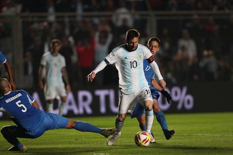 Leonel Messi (c) disputa un balón con Renato Punyed de Nicaragua. Foto: EFE