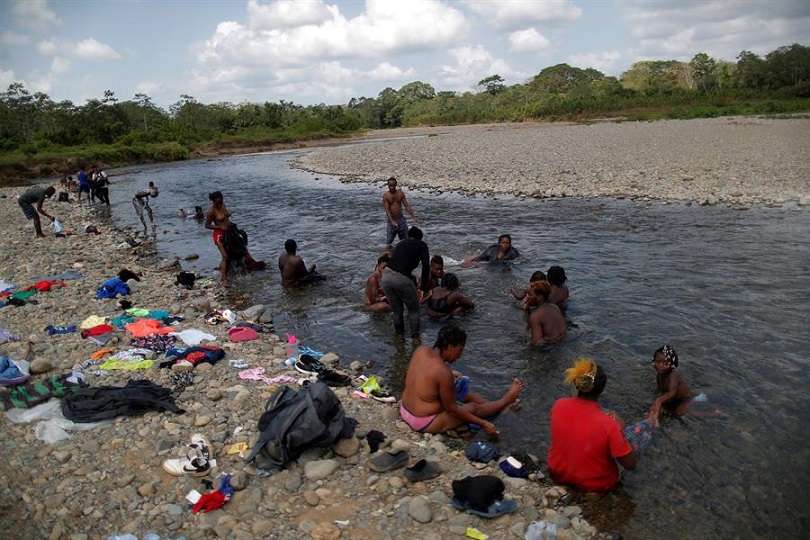 Migrantes haitianos se bañan en el río Tuquesa, en la comunidad de Bajo Chiquito, en Darién (Panamá). EFE/