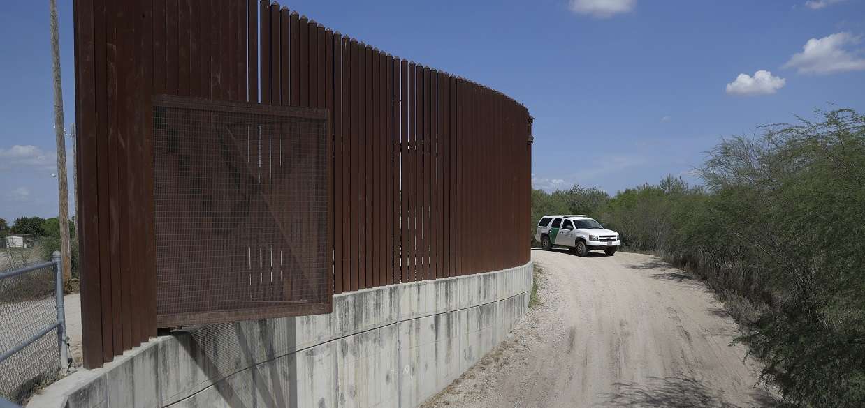 Un vehículo de la Patrulla Fronteriza y de Aduanas de EE. UU. pasa por una sección del muro del dique fronterizo en Hidalgo, Texas. AP