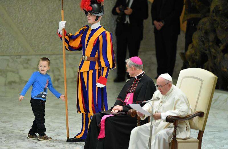 Un niño argentino de unos siete u ocho años accede al escenario del Aula Pablo VI mientras el papa Francisco (d) preside su audiencia general de los miércoles en el Vaticano. EFE