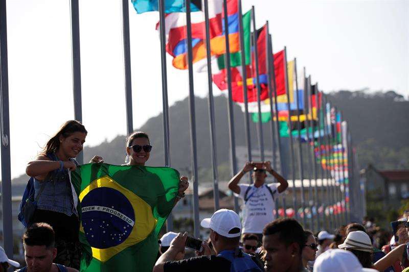Peregrinas brasileñas se toman una fotografía frente a la bahía de Panamá, junto a las banderas de los países que participarán en la Jornada Mundial de la Juventud (JMJ) el lunes 21 de enero de 2019, en Ciudad de Panamá. EFE
