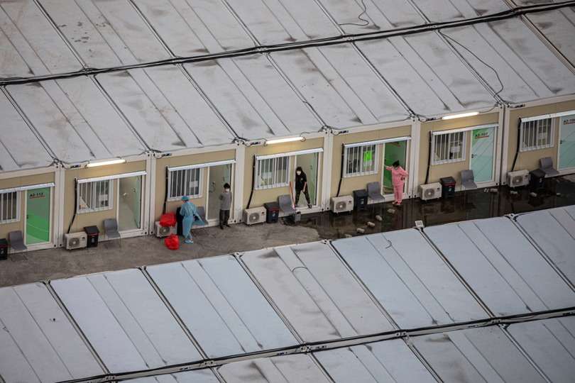 Personas aisladas frente a sus cabañas en la instalación de aislamiento comunitario de Tsing Yi en Hong Kong. EFE