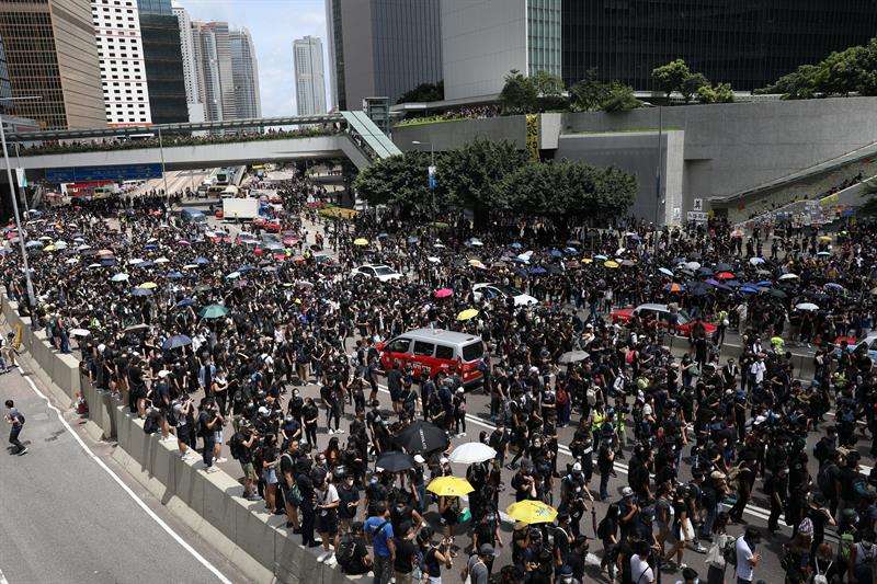 Manifestantes bloquean una calle principal fuera de los edificios gubernamentales en Hong Kong, China, 21 de junio de 2019. EFE