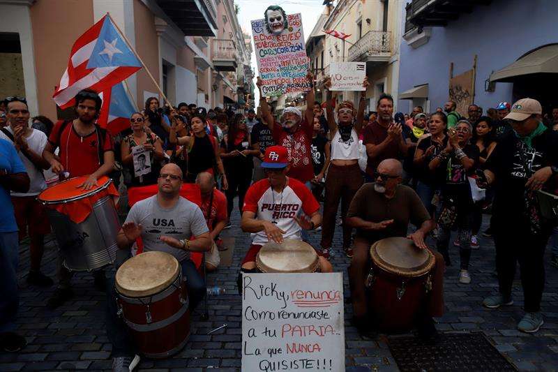 Manifestantes tocan música durante una protesta este jueves, por sexto día consecutivo, delante de la sede del Gobierno, más conocida como La Fortaleza, en San Juan (Puerto Rico). EFE