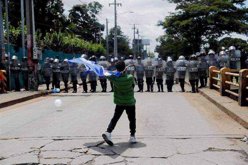 Manifestantes que participan en la marcha &quot;Rescatemos la Patria&quot;, en contra del presidente Daniel Ortega, recriminan a los policías antimotines que bloqueen el paso hoy, domingo 16 de septiembre de 2018, en Managua (Nicaragua). EFE