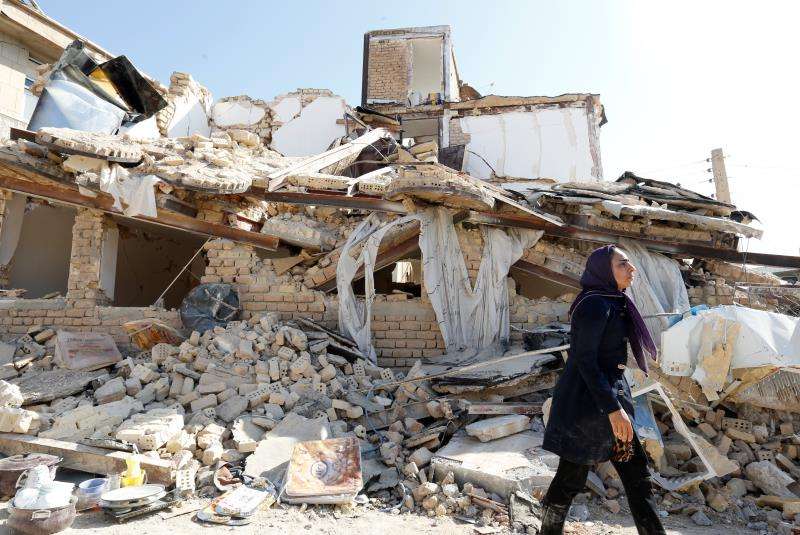 Una mujer iraní pasa delante una casa derrumbada en la localidad de Sare Pole-Zahab, provincia de Kermanshah (Irán) en el pasad0 noviembre de 2017. EFE/Archivo