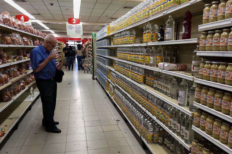 Personas buscan alimentos en un supermercado en la ciudad de Caracas (Venezuela). EFE/Archivo