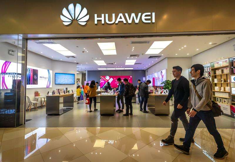 Personas caminan frente a la tienda de Huawei en Guangzhou (China). EFE