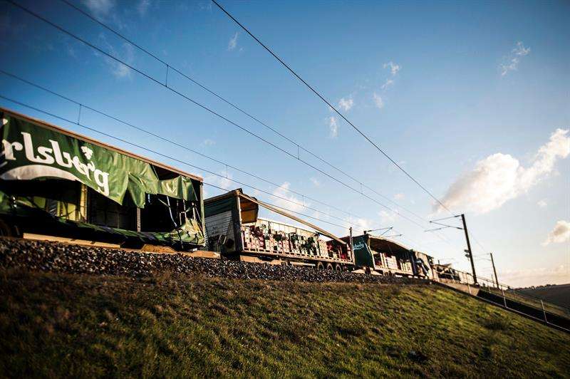 Varios operarios pasan junto un tren de carga en el puentoeGran Belt en Nyborg (Dinamarca). EFE