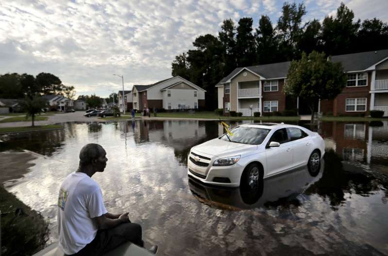 Augustin Dieudomme mira hacia la entrada inundada de su complejo de apartamentos cerca del río Cape Fear, ya que sigue aumentando después del huracán Florence en Fayetteville, Carolina del Norte. AP