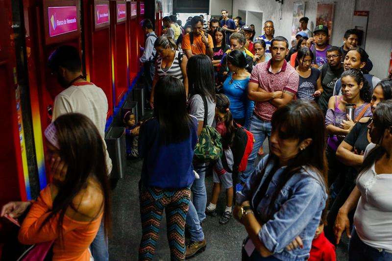 Personas hacen fila para retirar dinero en un cajero automático este miércoles, en Caracas (Venezuela). EFE