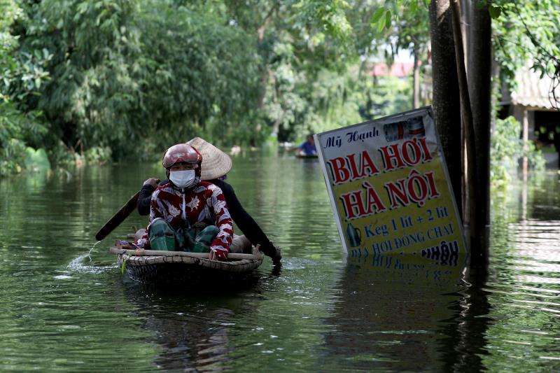 Un grupo de vietnamitas navega por una zona inundada en el municipio de Nam Phuong Tien, distrito de Chuong My en Hanói (Vietnam). EFE/Archivo