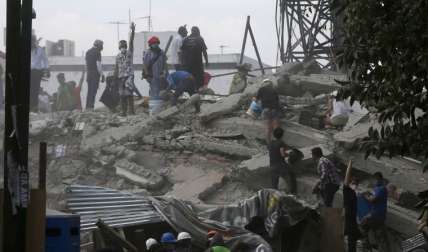 Un grupo de personas buscan sobrevivientes entre los edificios colapsados. FOTOAP