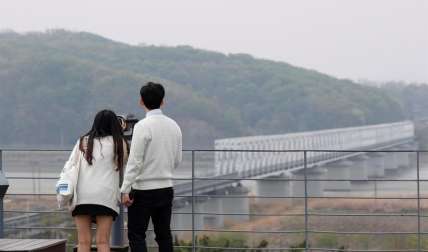 Dos turistas observan el lado norcoreano a través de unos binoculares en la zona desmilitarizada (DMZ) en Paju (Corea del Sur). EFE