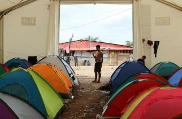 Un hombre espera en la entrada de un campamento en la estación de recepción migratoria Lajas Blancas. EFE / Archivo