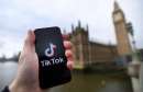 El logotipo de TikTok en un teléfono inteligente frente al parlamento británico en Londres 